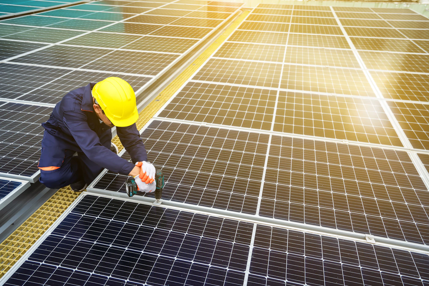 Técnico con casco trabajando junto a un panel solar